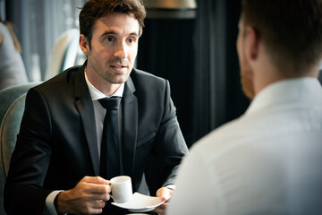 Sticker - Coffee break. Two cheerful business men talking in a restaurant