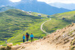 © robertharding - Mother with two little sons walking on path in green meadows towards Rifugio Sassopiatto, Dolomites, Trentino-Alto Adige, Italy