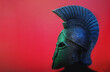 Ancient Spartan (Greek) warrior helmet on a red background with copyspace for text. Suitable for TV documentaries, history information etc.