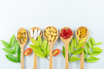 Wall Mural - Alternative medicine, pills tablet, capsule and vitamin organic supplements good for health in wood spoon on white background with copy space, medicine and drug concept