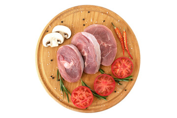 pieces of raw turkey meat, chopped leg steak, portioned barbecue pieces, on wooden board with rosemary, tomatoes and red hot pepper. isolate