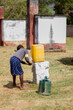 Child girl washing hands near a latrine in a makeshift water tap