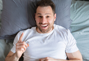 Aufkleber - Excited Man Having Idea Pointing Finger Up Lying In Bedroom