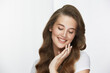 © veles_studio - lovely girl with light mua and curly long hair touching cheek and smiling