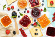 Toasts with jam with fresh berries on white wooden table