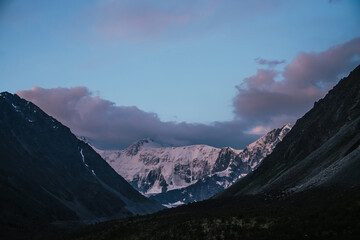 Wall Mural - amazing landscape of sunset with pink snowy mountains and lilac clouds. atmospheric highland scenery