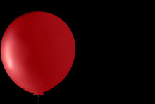A Red Party Balloon On A Black Background