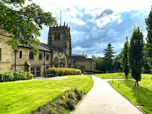 An Old Stone Cathedral With Grass Lawns, Trees, And A Footpath, In The Centre Of The City Of, Bradford, Yorkshire, UK