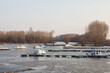 Panorama of the port of Kovin, on the Danube, with boats and ship anchored in frozen waters in winter. Kovin is a city of Vojvodina province, in the district of Banat