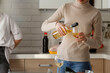 © Danil Nevsky/Stocksy - Woman in turtleneck pouring wine to glass in kitchen
