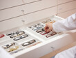 © MIQUEL LLONCH/Stocksy - Optician shop with eyeglasses drawer