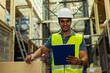 © twinsterphoto - Young Indian industrial factory warehouse worker working in logistic industry indoor. Smiling happy man holding a clipboard checking item merchandise stock order in storehouse