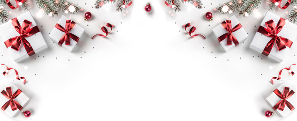 Wall Mural - creative frame made of christmas fir branches, gift boxes, red decoration, sparkles and confetti on 