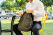 © VITTA GALLERY/Westend61 - Businessman zipping backpack while sitting on chair at sidewalk cafe
