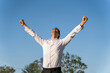 © VITTA GALLERY/Westend61 - Successful businessman with arms raised standing against clear blue sky
