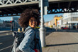 © Mattia Pelizzari/Westend61 - Smiling young woman with afro hair looking away while standing on sidewalk during sunny day