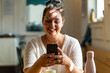 © Giorgio Fochesato/Westend61 - Close-up of smiling voluptuous woman using mobile phone while sitting in restaurant