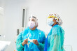 © Jose Luis CARRASCOSA/Westend61 - Doctor holding protective gloves while standing by assistant at office