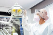 © Jose Luis CARRASCOSA/Westend61 - Doctor in protective workwear adjusting electric lamp in clinic