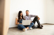 © MiJo/Westend61 - Couple using laptop while sitting against white wall in new unfurnished home