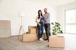 © MiJo/Westend61 - Happy couple standing by cardboard boxes and electric lamp in new unfurnished home