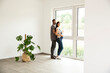 © MiJo/Westend61 - Pregnant woman standing with husband looking through window in new home