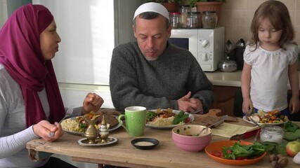 Wall Mural - Happy Authentic Muslim Family Eating Dinner Together At Home. Traditional Eastern Muslim Halal food on the table