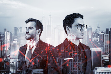 Two handsome young SMM specialists thinking about development of social media marketing strategy to achieve business goals. Hologram icons over Kuala Lumpur background.