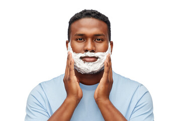 Wall Mural - grooming and people concept - african american young man with shaving cream on his beard over white background