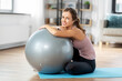 © Syda Productions - sport and healthy lifestyle concept - happy smiling young woman with fitness ball at home