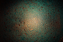 Cyan, Orange And Teal Oil Droplets Illuminated With Colored Bulb With Dark Background