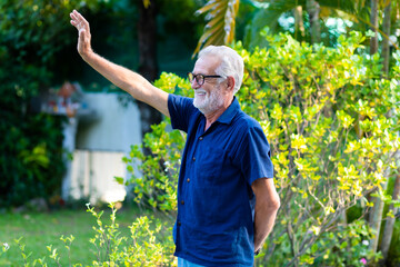 Wall Mural - family time together at home concept. lifestyle. Portrait of happy and handsome bearded senior man in glasses enjoy nature garden at home. Elder man