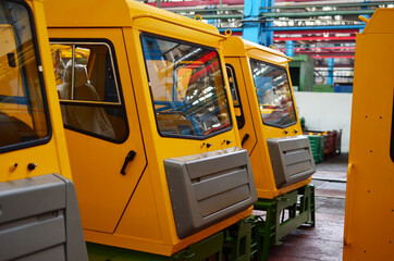 Production process of heavy mining trucks at the factory. Dump truck on the Industrial conveyor in the workshop of an automobile plant. Manufacturer of haulage and earthmoving equipment, haul trucksм