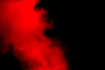 Wall Mural - red powder explosion on black background. freeze motion of red dust particles splash.