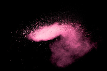 Pink dust particles splash on black background.Pink powder splash.