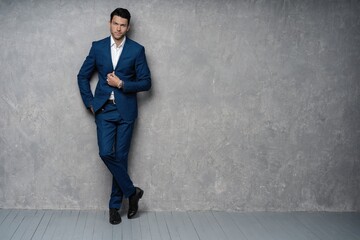 full length of handsome man wear blue suit isolated on grey background