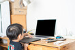 © themorningglory - Asian cute 2 year boy using laptop computer sitting on father chair at home.