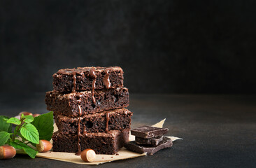 Wall Mural - The classic American cake is brownie. Chocolate cake with nuts on a black background.