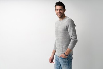 Wall Mural - Handsome young man on white background looking at camera. Happy guy smiling.