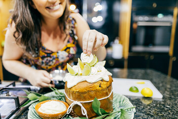 Brazilian woman preparing homemade panettone with meringue and lemon for Christmas dinner.