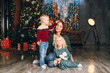 © irina_timokhina - Cute mother with daughter and son posing at the Christmas tree