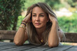© 22Imagesstudio - Portrait of happy and tired woman sitting outdoors holding her head with hands.