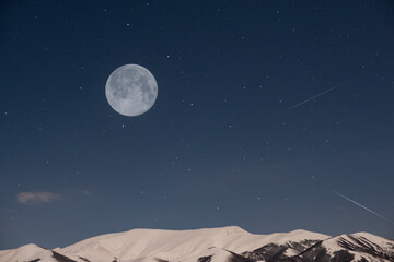 beautiful full moon on the starry sky. over the mountains.