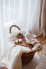 Christmas Decor. Mug, Christmas Candy, Christmas Cookies, Knitted Sweater, Wicker Basket Against The Background Of A Christmas Tree. Cozy Holidays.