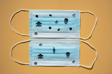 Protective surgical masks with skulls and rhinestones. Hallowing concept. Isolated on beige background