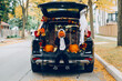 © anoushkatoronto - Trick or trunk. Child boy celebrating Halloween in trunk of car. Kid with red carved pumpkin celebrating traditional October holiday outdoors. Social distance and safe alternative celebration.