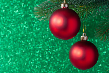 two red shiny ball on a new year tree branch on a green blurred background, mock up.