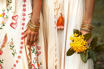 close up of two beautiful young woman in summer dresses outdoors at sunset