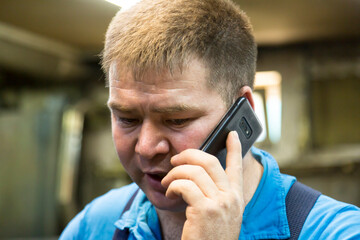 Wall Mural - Close-up portrait of a man in the workplace with a mobile phone