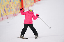 Active Little Girl In Pink Ski Suit Skiing On Winter Snow Hill Holding Poles During Christmas Eve Holiday Vacation Leisure Activity